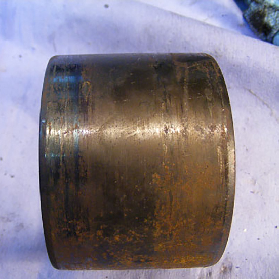 Damaged outer surface of a double row Tapered Roller Bearing, Marks consistent with the ring having been loose in the application due to housing wear and dimensional inaccuracy. Discolouration to a deep blue caused by overheating at one side as a result of uneven loading